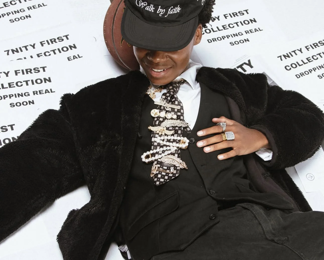 7nity faux-fur overcoat styled with waistcoat and tie on campaign posters
